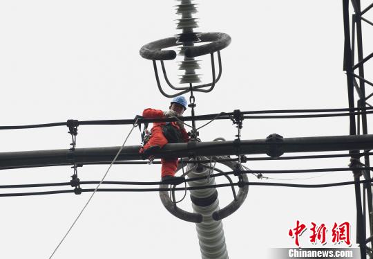 圖為電力工人在70多米高空作業(yè)，為特高壓復奉線重慶段進行八年來首次大修。　周毅 攝